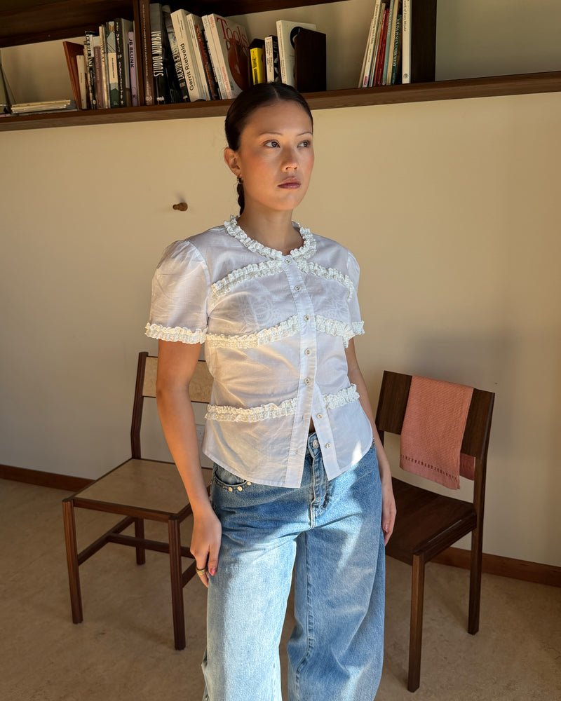 MARTHA BLOUSE WHITE | An update to our Martha Top, this blouse is designed in a semi-sheer organic cotton and features ruffle detailing around the neckline, sleeves and front. Pair with denim for a sweet and simple look. 