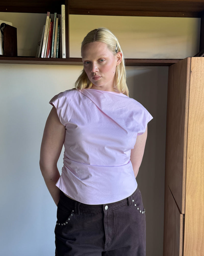BOWIE TOP PINK | Short sleeve top crafted in a pink organic cotton, featuring a high neck collar and gathered detailing on the lower back and side seam, designed for better fit and movement. Perfect for any occasion, this versatile piece is a great...