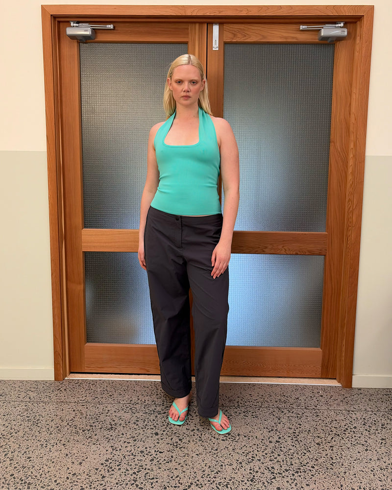 RUDI TANK AQUA | A twist on the classic halter tank with an oversized strap designed to sit gathered around the neckline, crafted in a mid-weight aqua knit. This tank is designed to be worn tight and hold you in when worn. Pair with...