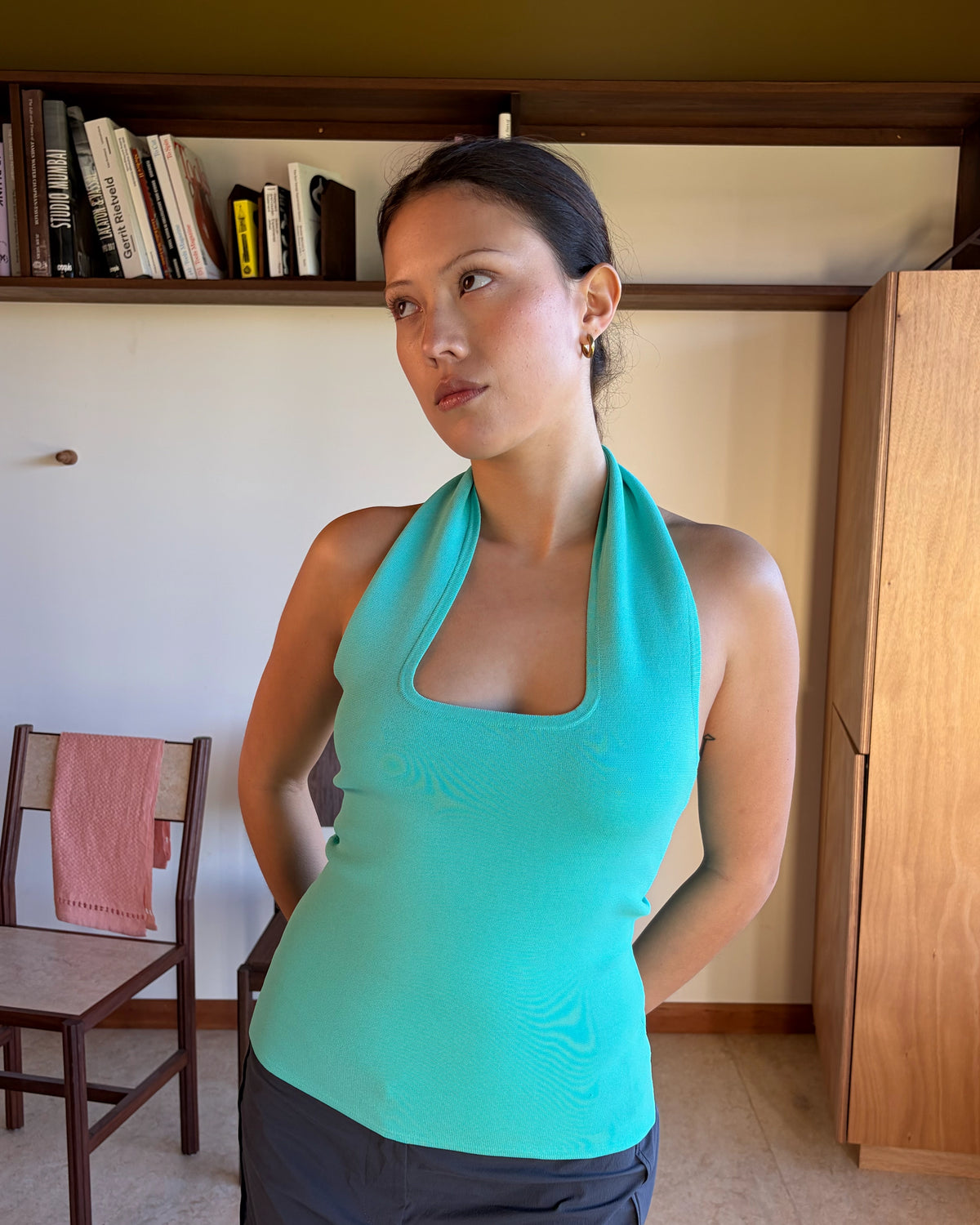 RUDI TANK AQUA | A twist on the classic halter tank with an oversized strap designed to sit gathered around the neckline, crafted in a mid-weight aqua knit. This tank is designed to be worn tight and hold you in when worn. Pair with...