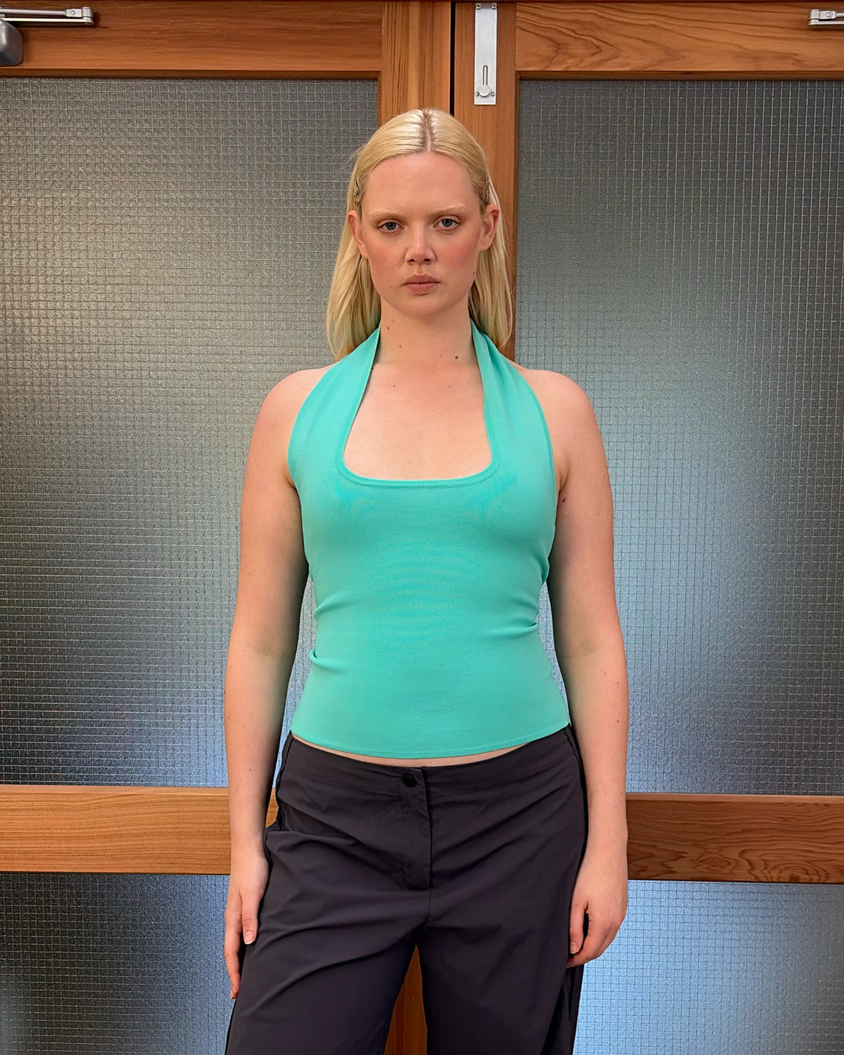 RUDI TANK AQUA | A twist on the classic halter tank with an oversized strap designed to sit gathered around the neckline, crafted in a mid-weight aqua knit. This tank is designed to be worn tight and hold you in when worn. Pair with...