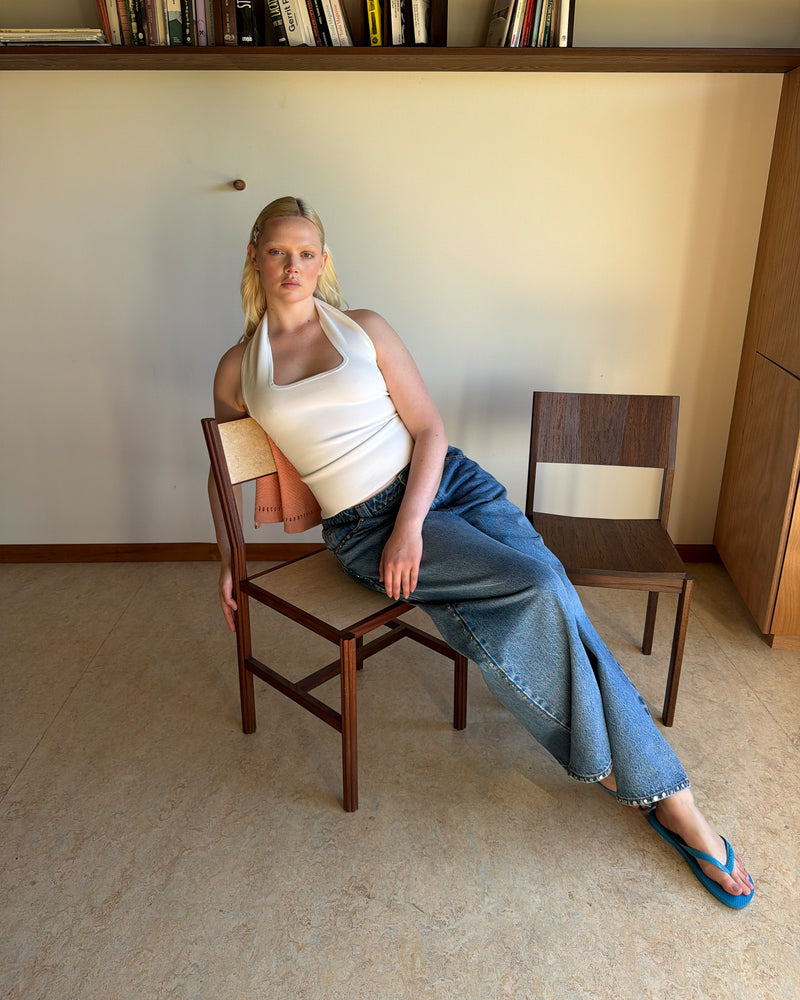 RUDI TANK WHITE | A twist on the classic halter tank with an oversized strap designed to sit gathered around the neckline, crafted in a mid-weight white knit. This tank is designed to be worn tight and hold you in when worn. Pair with...