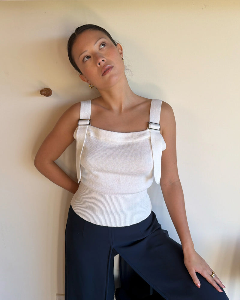 BODE BUCKLE TANK WHITE | White knit tank with buckle features on the straps and a fitted waist, designed in 100% organic cotton. An elevated take on a classic piece, pair with denim for a chic everyday look. 