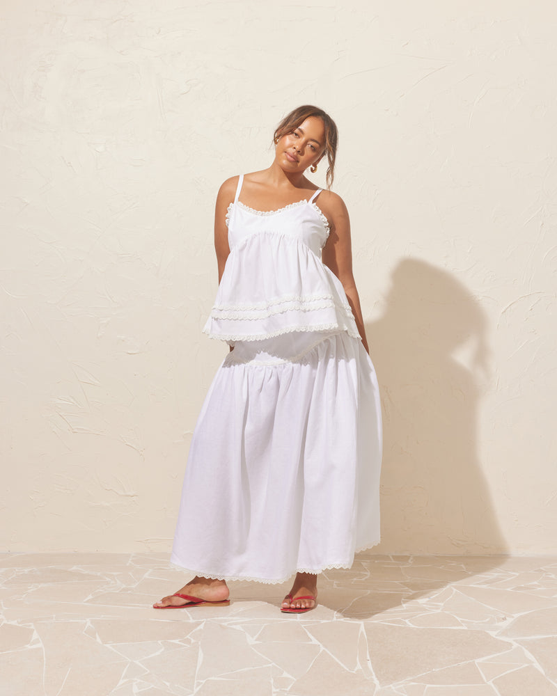 TRULLI SKIRT WHITE LINEN | Floaty basque style maxi skirt imagined in a white linen. This skirt features a bodice-style waistline, that falls to a full, wide skirt. Lace trim at the dropped waistline and...