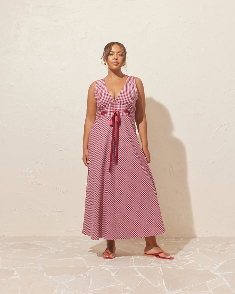 FLORY DRESS PINK BURGUNDY GINGHAM | Sleeveless sundress with a V-neckline, designed in a contrasting pink and burgundy gingham. This dress has all the details covered, with a pleated under bust and contrast colour adjustable ribbon,...