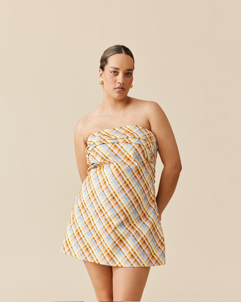 CHER MINI DRESS YELLOW TARTAN | This mini dress has a fitted bodice, with tucks crossing the bust, falling to mid-thigh. Cut in a retro-inspired yellow tartan print on a cotton drill fabric, the structure and...