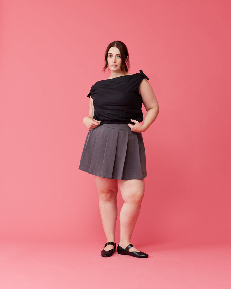 CARMY MINI SKIRT CHARCOAL | Pleated mini skirt designed in a suiting fabric. Cute and to the point, this skirt will become a wardrobe staple.