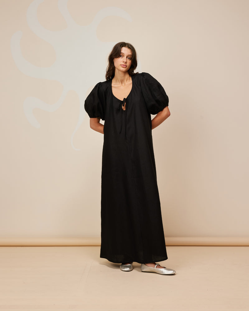 ANGEL LINEN MAXI DRESS BLACK | Relaxed fit maxi dress with elasticated puff sleeves and a tie neckline with a keyhole detail. Crafted in an airy linen, the puff sleeves add a romantic feel to this...