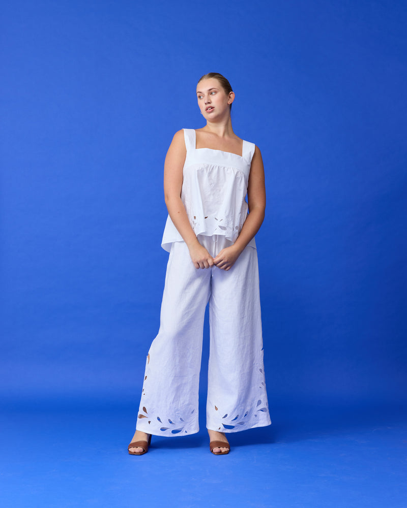 MARGIE TIE-BACK TOP WHITE EMBROIDERY | Sleeveless top with a square band at the bust, in a summery embroidered linen. Features a bow tie detail at the back and a cut-out, the cutest summer top worn...