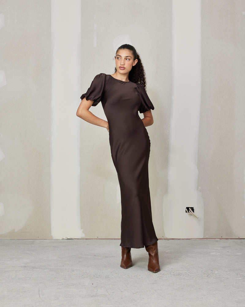 KENDALL SATIN  DRESS ESPRESSO | Bias cut satin midi dress with puff sleeves and a keyhole button closure at the back neck. The bias silhouette of this dress gently contours the body, while the espresso...
