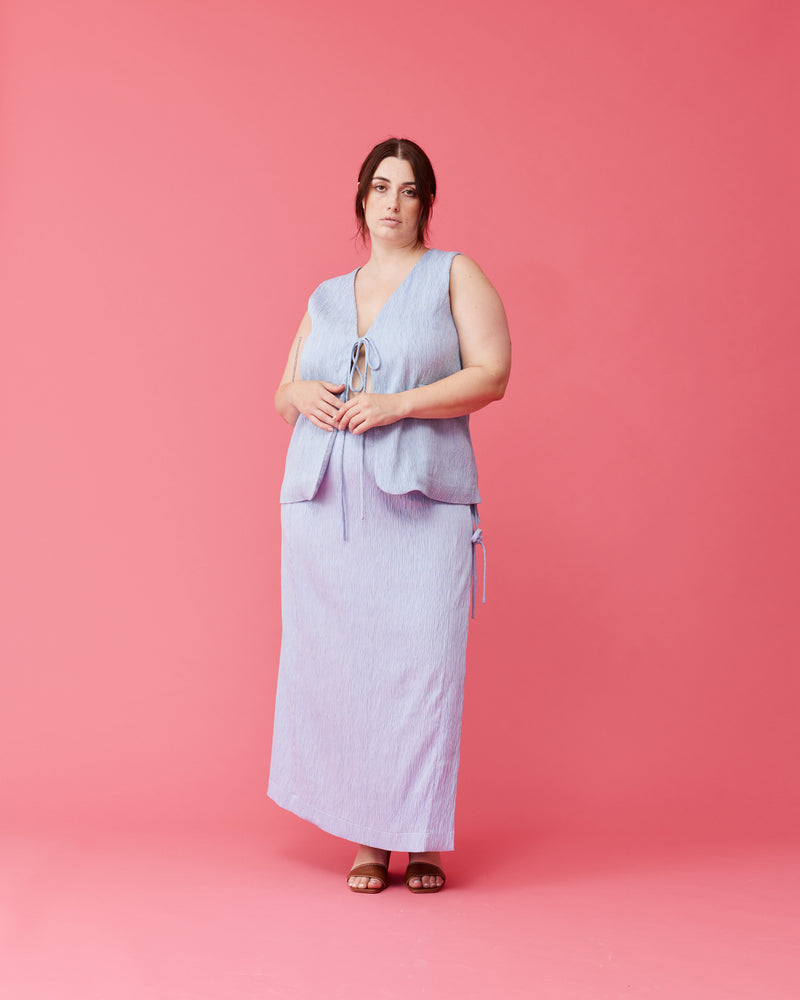 LOU TIE SKIRT PASTEL BLUE | Wrap midi skirt designed in a textured pastel blue fabric. This staple skirt is elevated by the 3 ties at the side of the skirt.