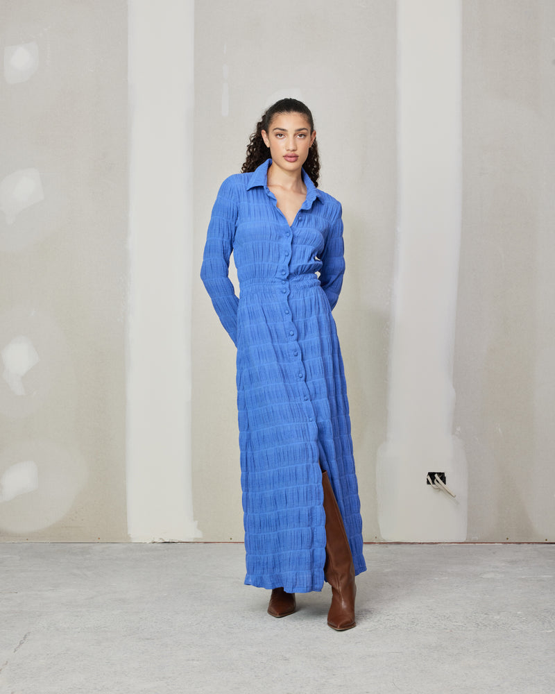 MIRELLA SHIRT DRESS PERIWINKLE | 
Button down shirt dress with self fabric buttons designed in our signature Mirella fabric. Has an elasticated waist that falls to a soft a-line skirt.