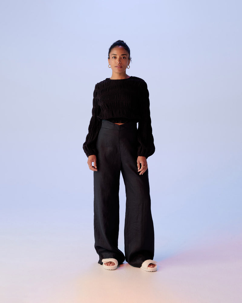 FRANKA LINEN PANT BLACK | Highwaisted wide leg linen pant with a crossover waistband. The waistband is thick and fits closely to flatter the form, while the linen fabrication gives this piece wearability for everyday.