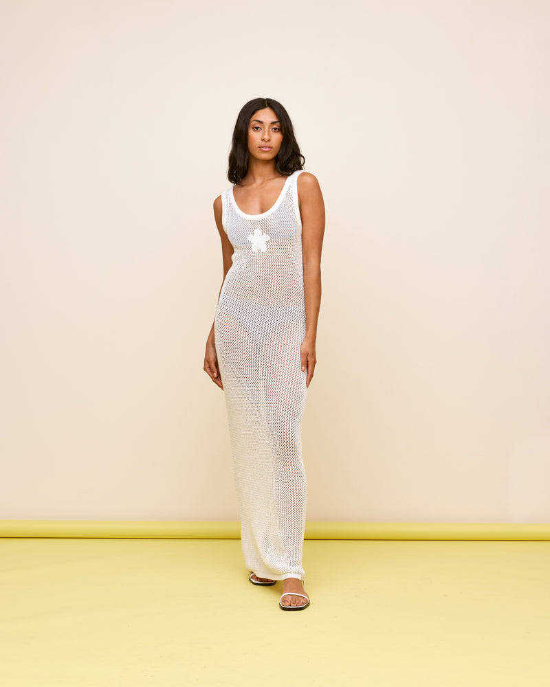  PAMELA CROCHET DRESS WHITE | Tank-style crochet maxi dress in a soft white cotton. Features ribbing around the round neckline and arms, finished off with a bold daisy at the centre front.