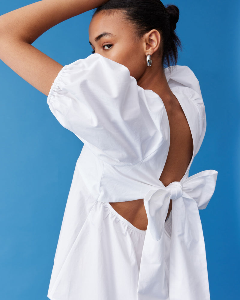 MARGIE TIE-BACK BLOUSE WHITE | Cotton puff sleeve top with a square band at the bust. Features a bow tie detail at the back and a cut-out, the cutest top worn with your favourite denim....