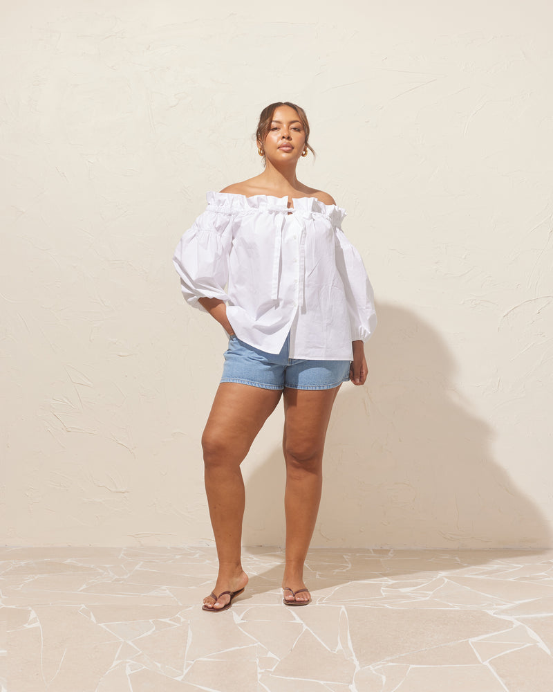 RELAXE BLOUSE WHITE | Button-down off-shoulder blouse designed in a crisp organic cotton, with a relaxed fit. This blouse features a bow tie at the centre, and elasticated sleeve cuffs and neckline for you...