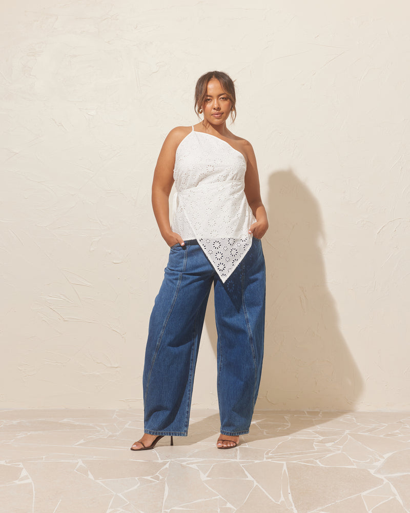 LEONIE WRAP TOP WHITE | One-shoulder cotton top, with wrap detailing that can be tied as you wish to adjust the waist cinching. The asymmetrical shape creates structure, while the broderie adds a soft, fun...