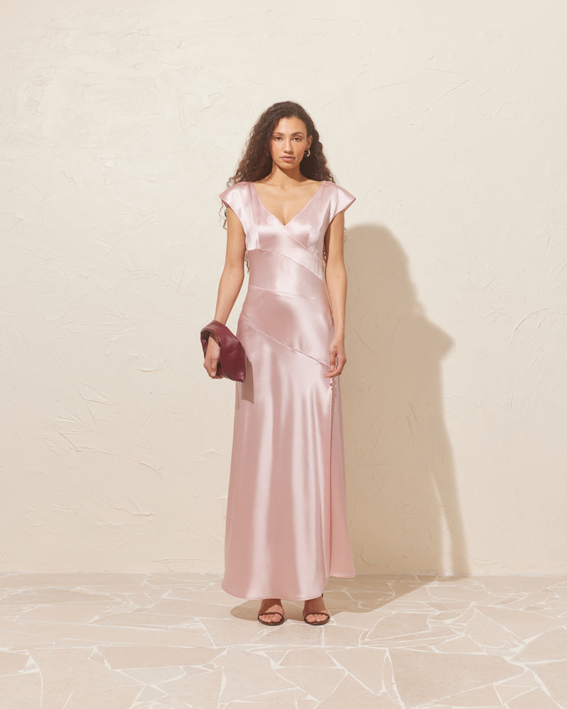 LIV GOWN PINK | Cap sleeve gown designed in a luxe pink satin. This show-stopping piece features asymmetrical patchwork detailing throughout and a side split for movement.