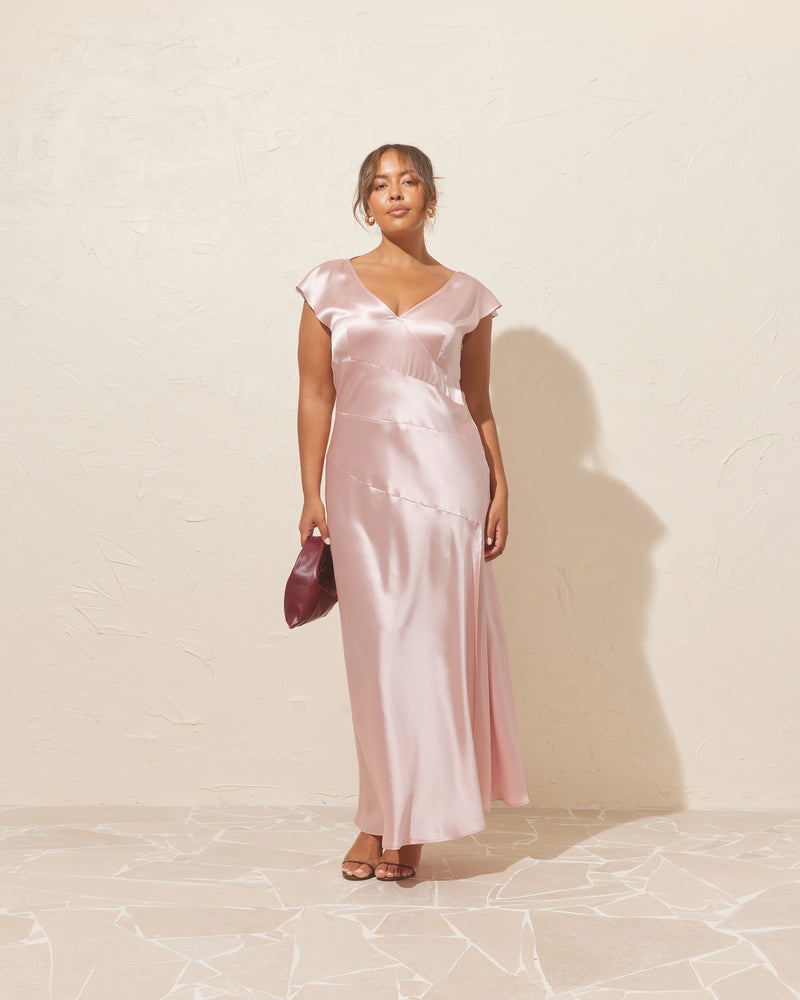 LIV GOWN PINK | Cap sleeve gown designed in a luxe pink satin. This show-stopping piece features asymmetrical patchwork detailing throughout and a side split for movement.