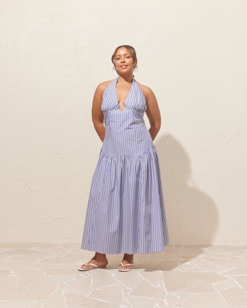 RELAXE HALTER DRESS NAVY STRIPE | Halter maxi dress designed in a navy striped organic cotton. This dress is fitted through the body, and then falls to a floaty basque-style skirt. Features a bodice-style waistline with...