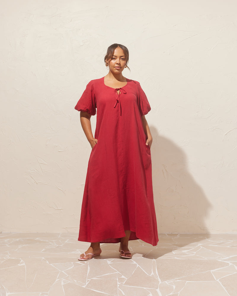 ANGEL LINEN MAXI DRESS SANGRIA | Relaxed fit maxi dress with elasticated puff sleeves and a tie neckline with a keyhole detail. Crafted in an airy linen, the puff sleeves add a romantic feel to this...