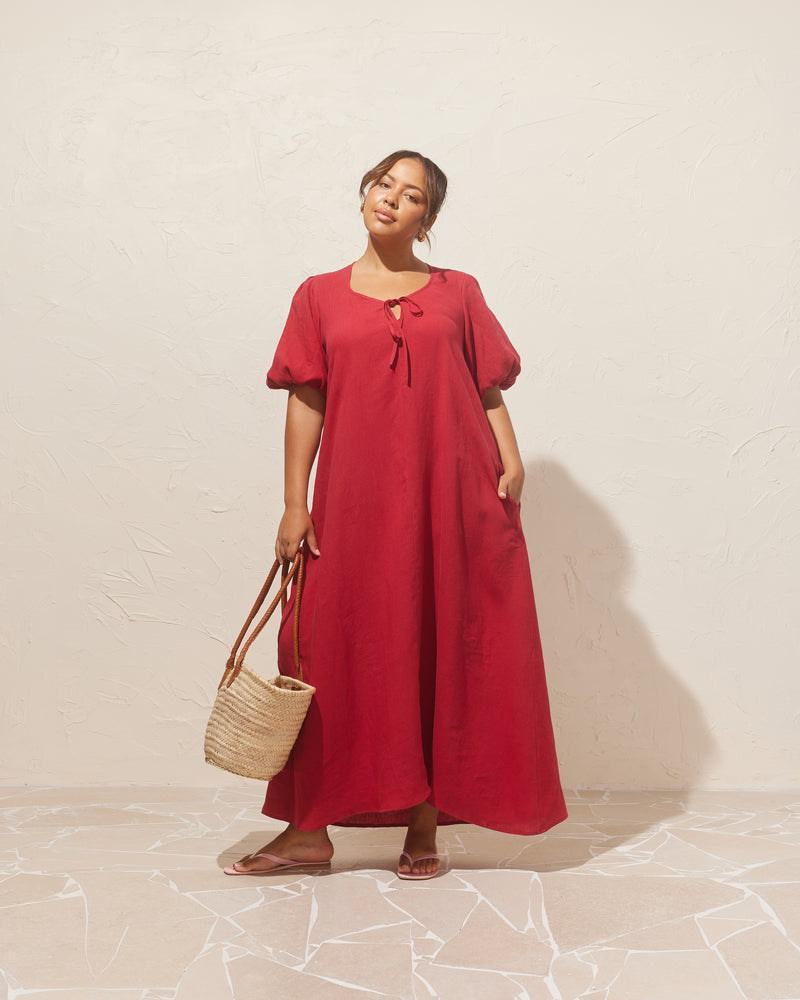 ANGEL LINEN MAXI DRESS SANGRIA | Relaxed fit maxi dress with elasticated puff sleeves and a tie neckline with a keyhole detail. Crafted in an airy linen, the puff sleeves add a romantic feel to this...