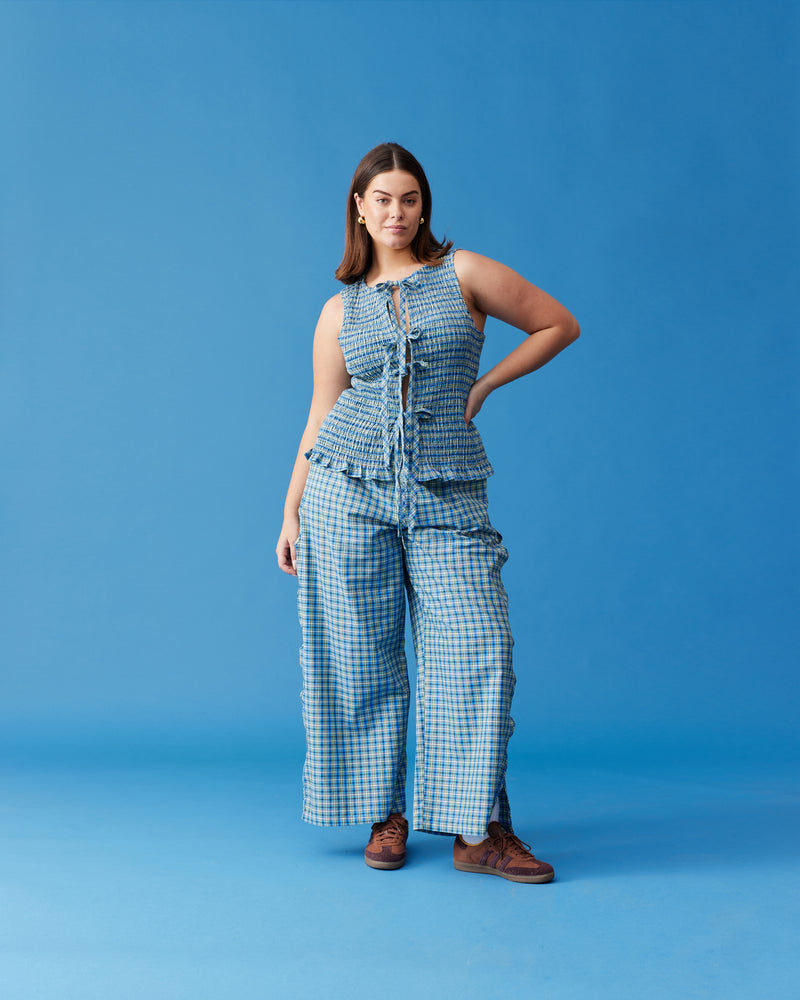 TRULLI TIE TOP BLUE YELLOW CHECK | Sleeveless shirred tank top, with tie closures down the centre front. This tank is designed in a blue and yellow checked cotton, and pairs with our Trulli Pant.
