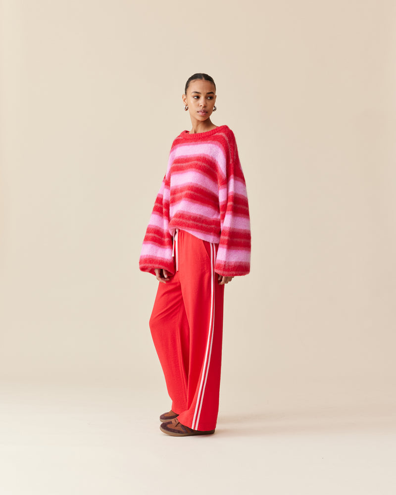 CORVETTE TROUSER RED PINK | A new take on the an all-time RUBY favourite. The Corvette Trouser is now available in a two-tone version. Sporty, high-waisted pant with a wide-leg silhouette. The stripe on the...