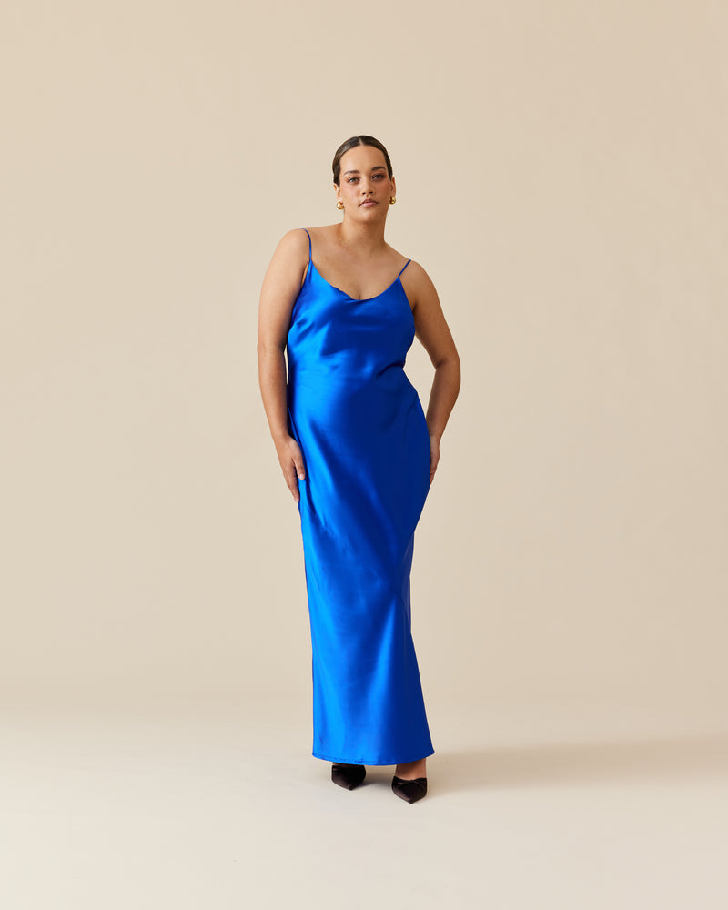 LOGAN SATIN SLIP SAPPHIRE | Bias cut maxi dress designed in a rich sapphire blue satin. This dress has a form-fitting shape with a scooped neckline and adjustable spaghetti straps.
