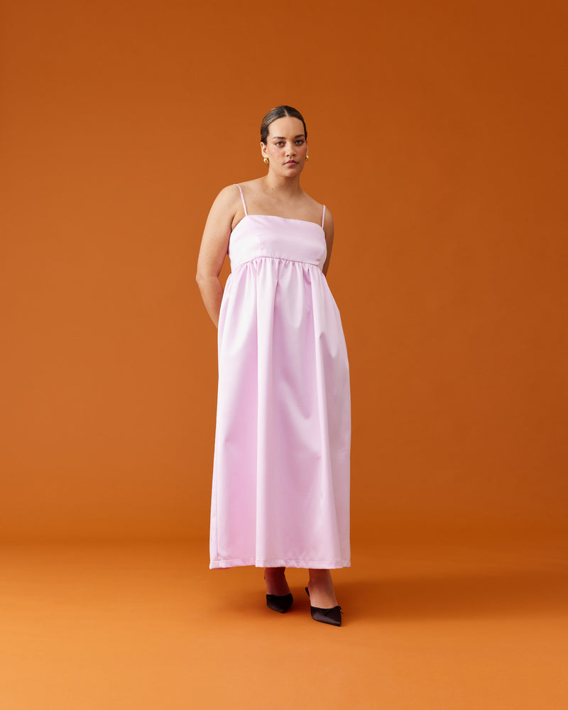 CHER MAXI DRESS SOFT PINK | A-line maxi dress designed in a luxe heavy-weight satin. This dress has a square banded bust with darts for shaping, and falls to a softly gathered skirt with pockets. Simple...