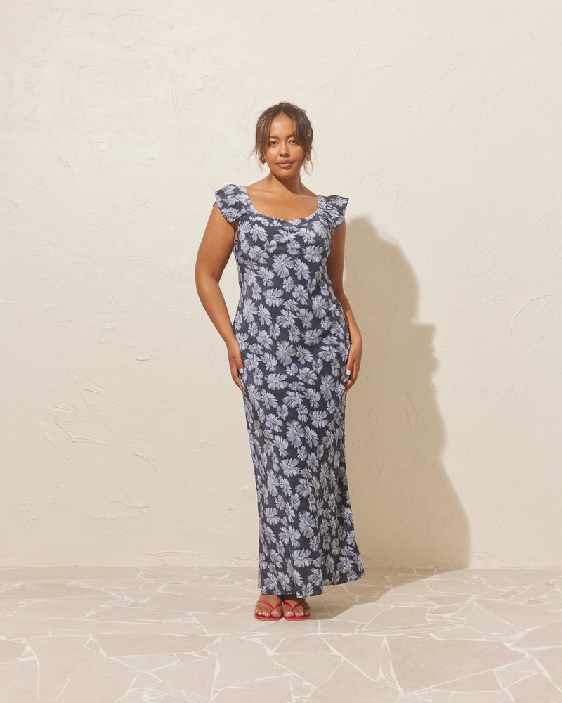 THEA DRESS DENIM DAISY | Bias cut maxi dress imagined in a denim daisy viscose fabric, with a silk-like hand feel and look. This slip dress features ruffled cap sleeves and a round neckline, that...