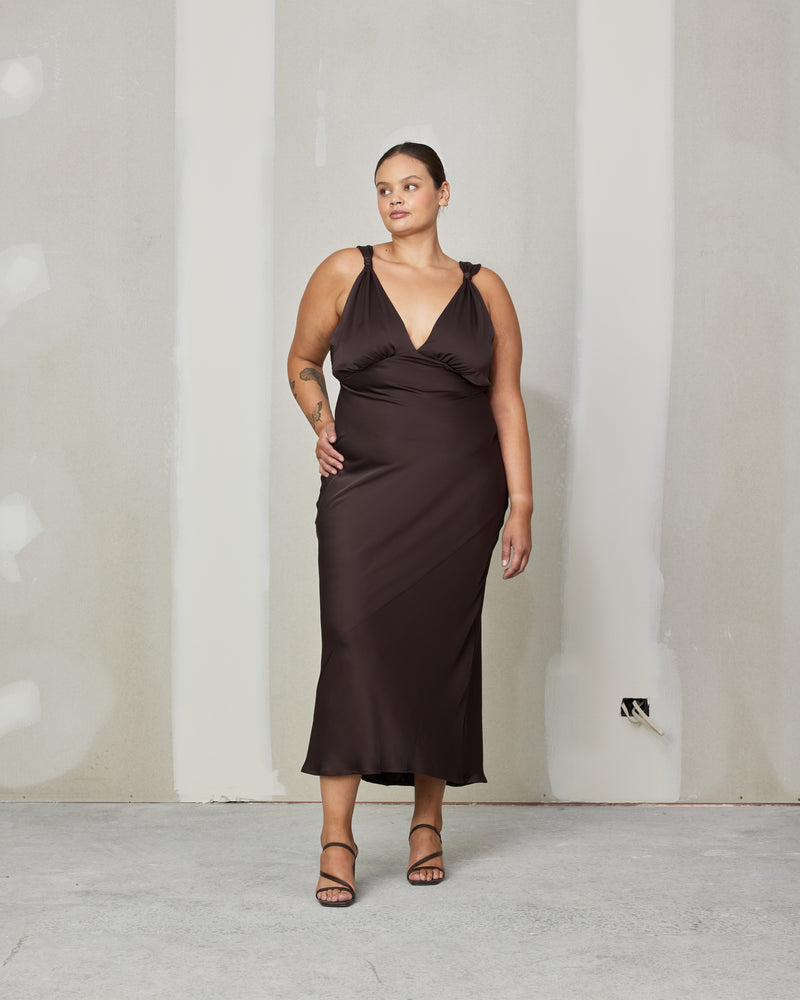 SUBLIME SATIN GOWN ESPRESSO | 
Bias cut satin sleeveless gown with a plunge neckline and open back in a luxe espresso shade. Features a knot detail at the shoulder and gathered detailing at the bust.