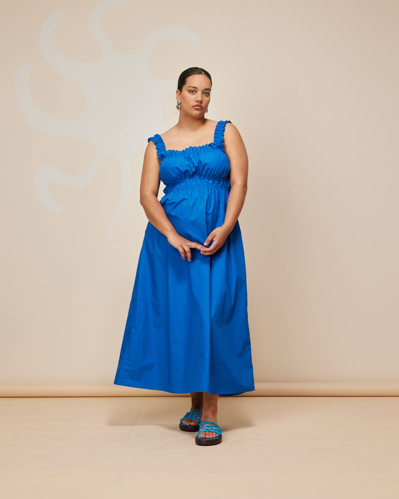 TRULLI DRESS COBALT | Sleeveless cotton midi dress with a square neckline and shirred bodice and straps. This dress falls to a full A-line skirt, that features pockets to house all your essentials.
