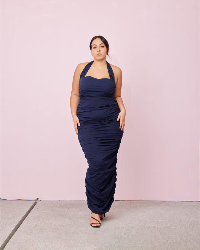 ARIEL HALTER DRESS NAVY | Crafted in a navy cotton, this dress features a halter neck and ruching down the side seams for a pleated look throughout. 