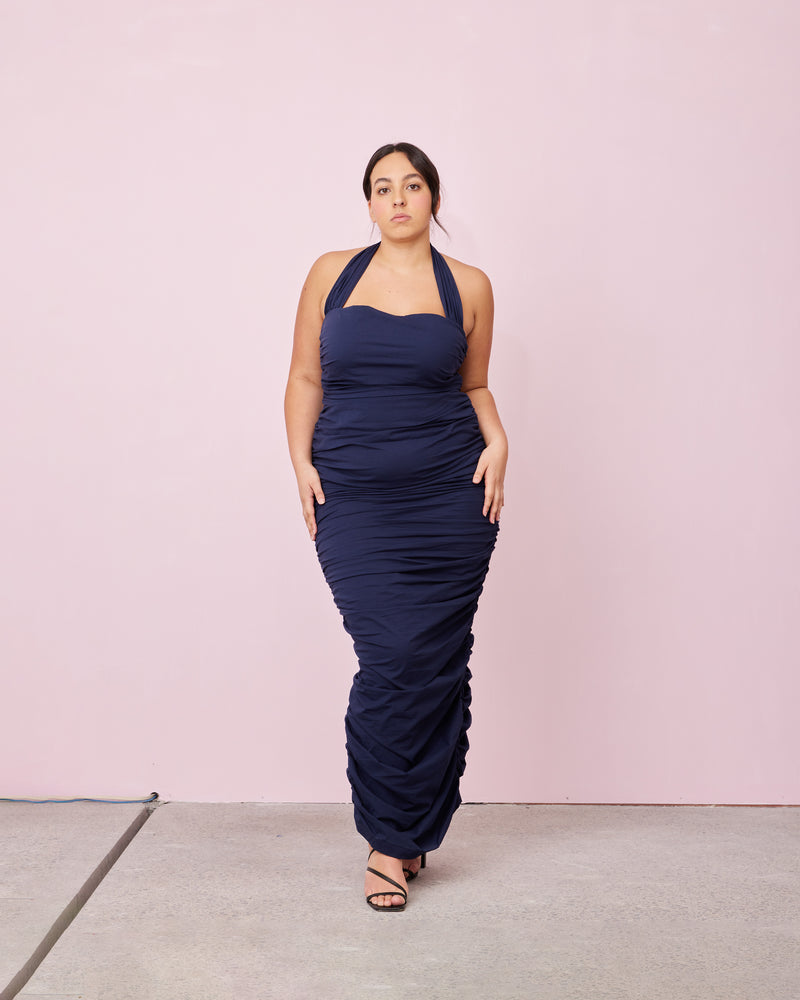 ARIEL HALTER DRESS NAVY | Crafted in a navy cotton, this dress features a halter neck and ruching down the side seams for a pleated look throughout. 