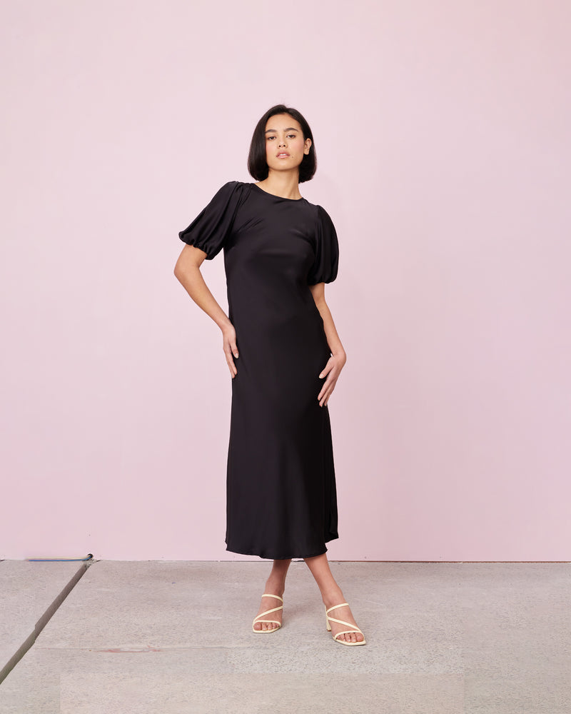 KENDALL SATIN DRESS BLACK | Bias cut satin midi dress with puff sleeves and a keyhole button closure at the back neck. The bias silhouette of this dress gently contours the body, while the satin...