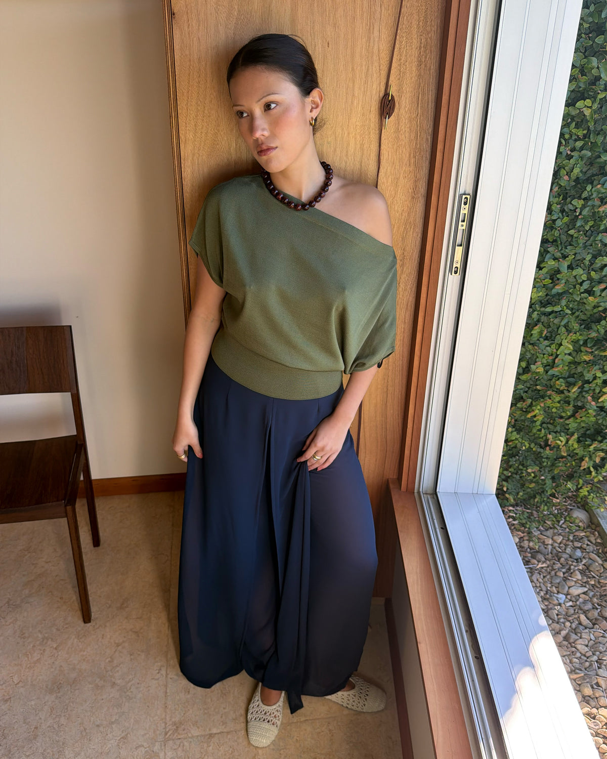 BODE BATWING SHORT SLEEVE TOP OLIVE | Off-shoulder batwing short sleeve top crafted in a mid-weight olive knit. This top is simple yet elevated and can be worn on or off the shoulder. Pair it with denim for a chic everyday look.