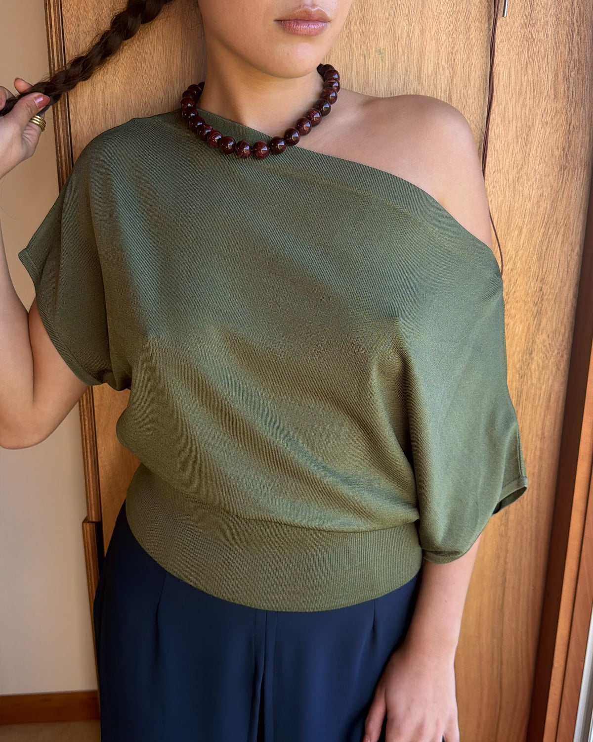 BODE BATWING SHORT SLEEVE TOP OLIVE | Off-shoulder batwing short sleeve top crafted in a mid-weight olive knit. This top is simple yet elevated and can be worn on or off the shoulder. Pair it with denim for a chic everyday look.