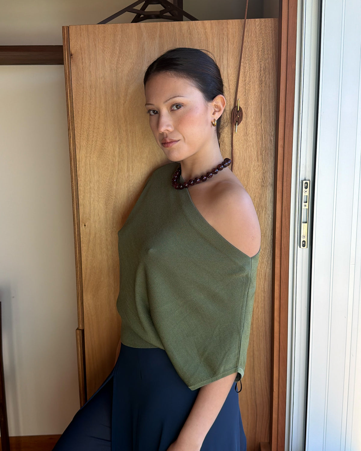 BODE BATWING SHORT SLEEVE TOP OLIVE | Off-shoulder batwing short sleeve top crafted in a mid-weight olive knit. This top is simple yet elevated and can be worn on or off the shoulder. Pair it with denim for a chic everyday look.