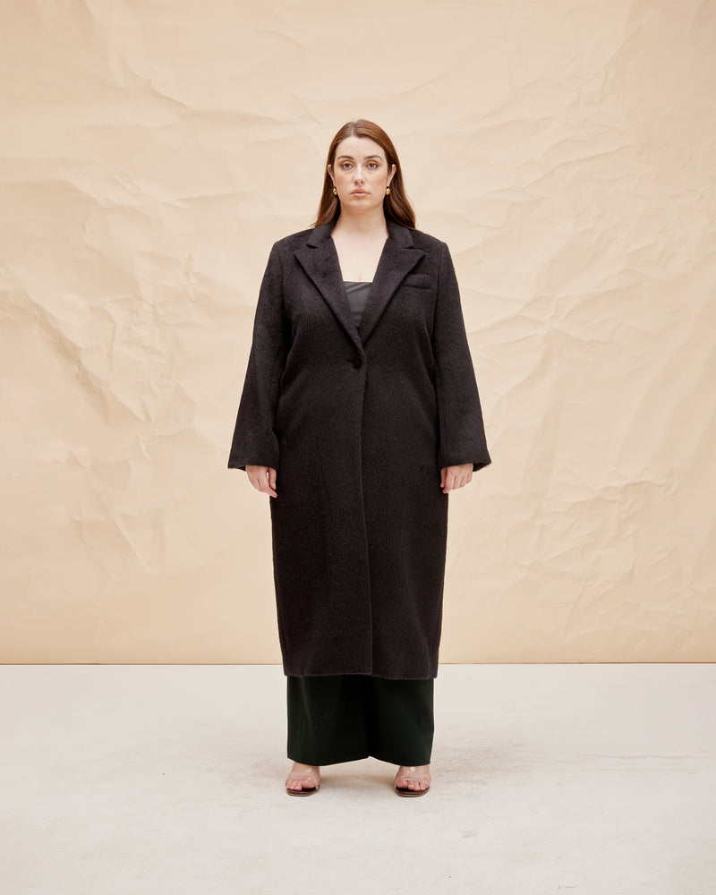 AUGUST COAT BLACK | Longline coat with a double breasted collar and front pocket detail, cut in black, this has a plush handle. Wearing this coat feels like being wrapped in a cosy blanket...