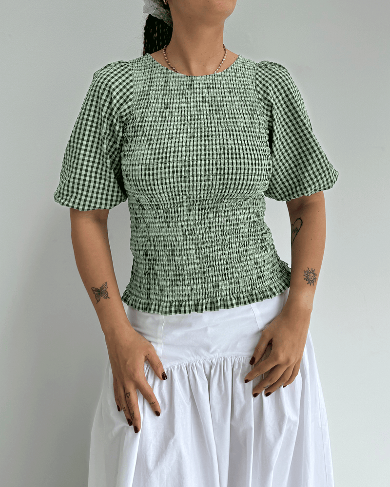 SKY PUFF SLEEVE TOP FOREST GINGHAM | Short sleeve blouse designed in a forest green gingham cotton. This blouse features shirring throughout, making it stretchy and close-fitting to the body.
