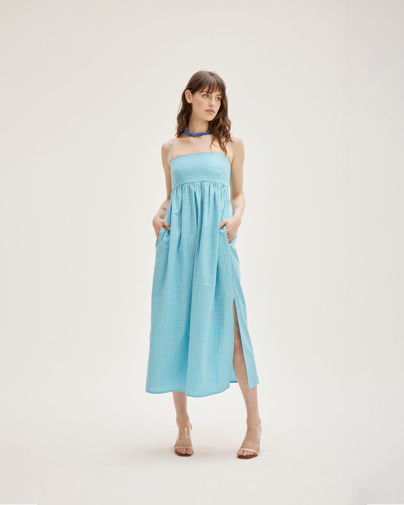 SPRITZ SUNDRESS AQUA GINGHAM | Cotton bandeau sundress cut in a striking new two-tone aqua gingham, featuring a shirred back, straight neckline and pockets to house your essentials. This piece is softly gathered under the...