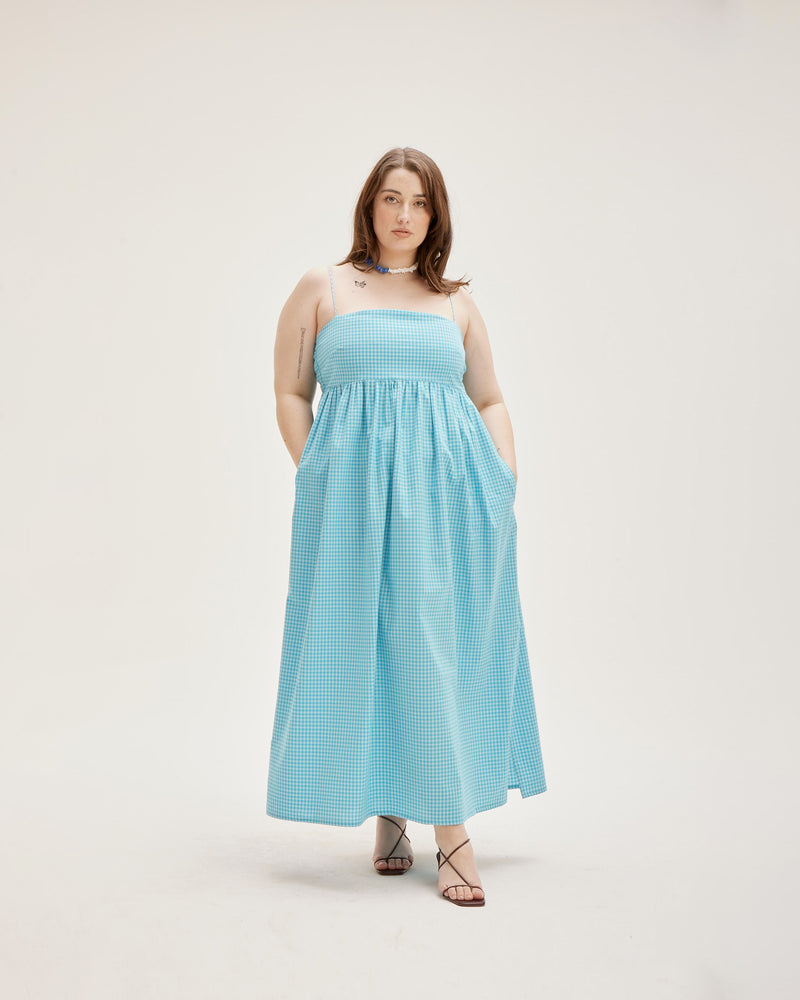 SPRITZ SUNDRESS AQUA GINGHAM | Cotton bandeau sundress cut in a striking new two-tone aqua gingham, featuring a shirred back, straight neckline and pockets to house your essentials. This piece is softly gathered under the...