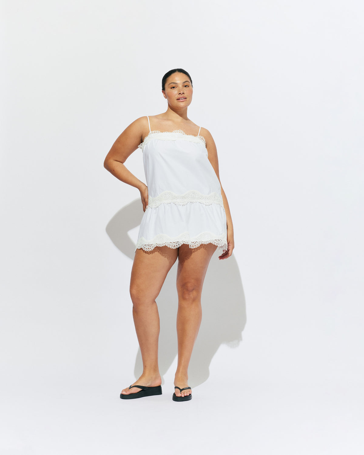TIDE MINI DRESS  WHITE | A-line mini dress with broderie trim details along the hem and bust, designed in our white organic cotton. With tiered skirt and adjustable straps, this is the perfect everyday summer dress.