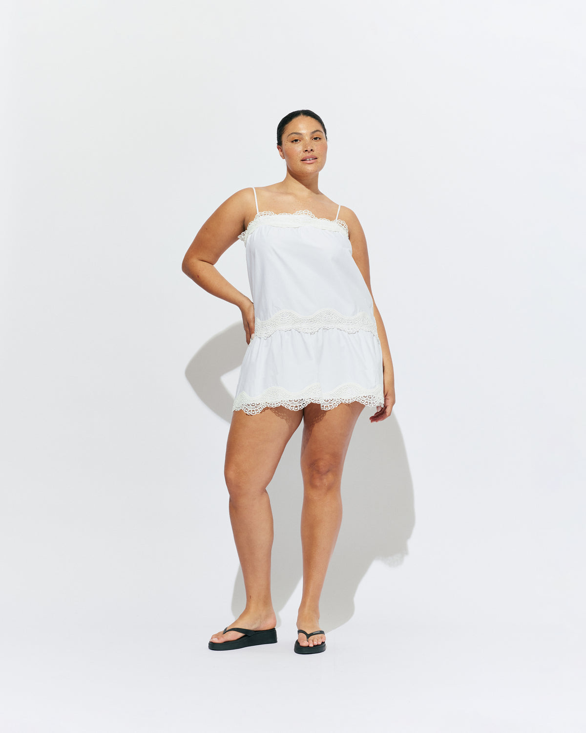 TIDE COTTON MINI DRESS WHITE | A-line mini dress with broderie trim details along the hem and bust, designed in our white organic cotton. With a tiered skirt and adjustable straps, this is the perfect everyday summer dress.
