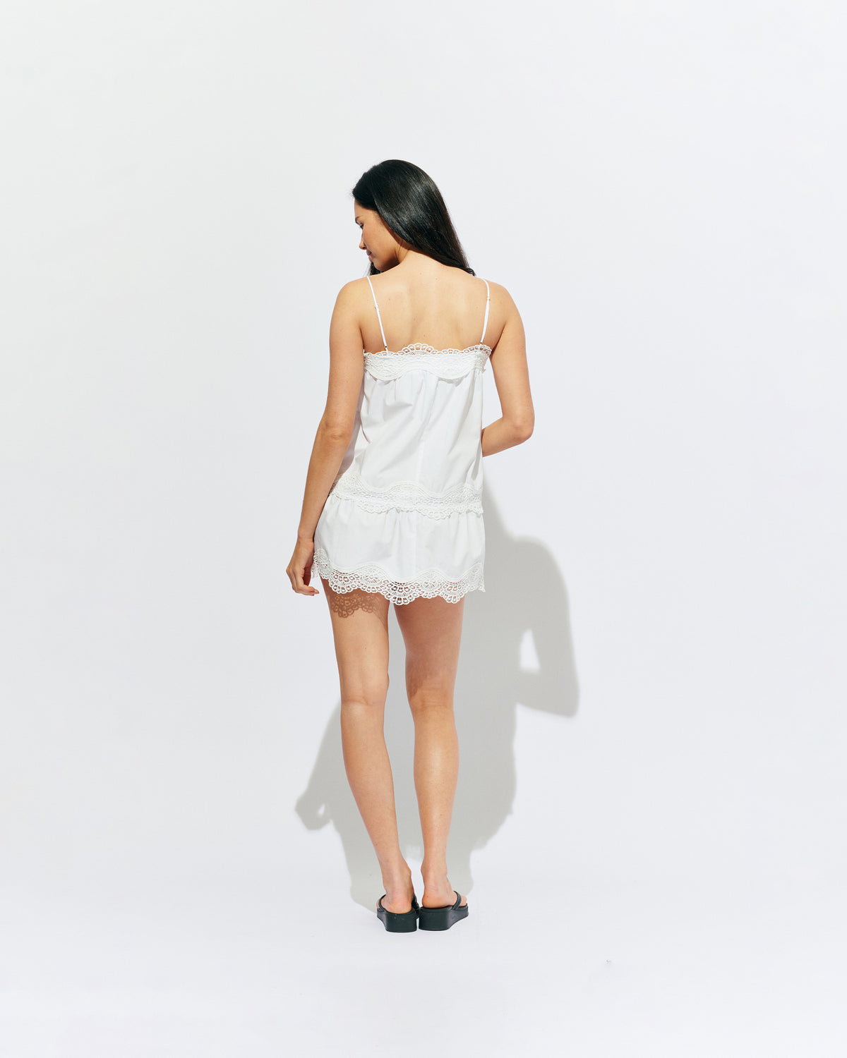 TIDE MINI DRESS  WHITE | A-line mini dress with broderie trim details along the hem and bust, designed in our white organic cotton. With tiered skirt and adjustable straps, this is the perfect everyday summer dress.