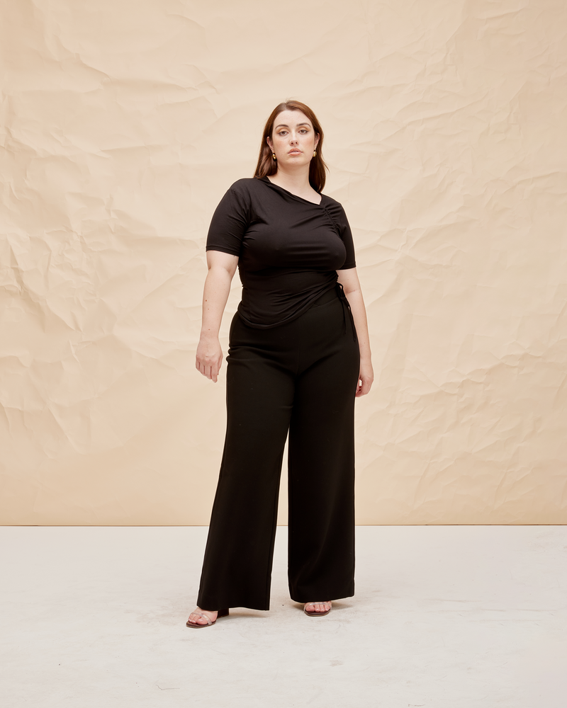 FRANKA PANT BLACK | Highwaisted wide leg pant with a crossover waistband. The waistband is thick and fits closely to the form, while our new suiting fabric creates structure in the leg.