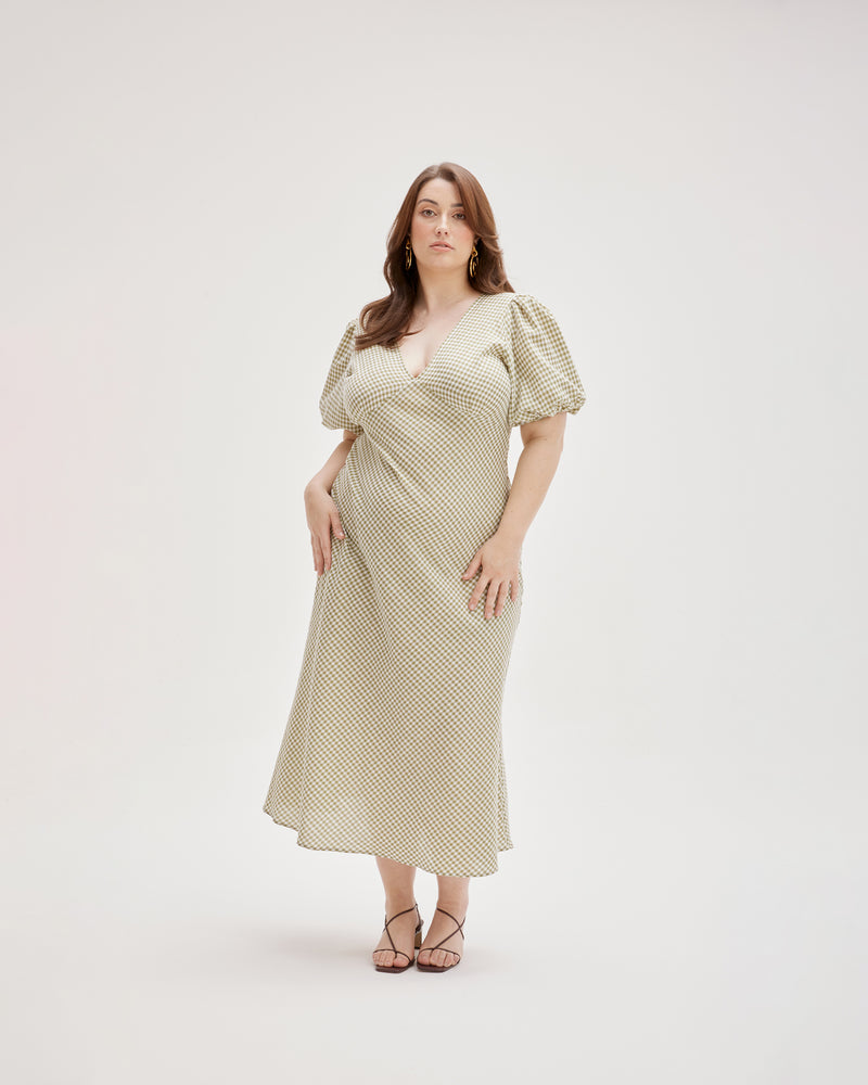 UMA DRESS KHAKI GINGHAM | Bias cut linen maxi dress with tie closure and a V-neck front and back. Cut in a khaki gingham, with elasticated puff sleeves and ruched detailing under the bust, it's...