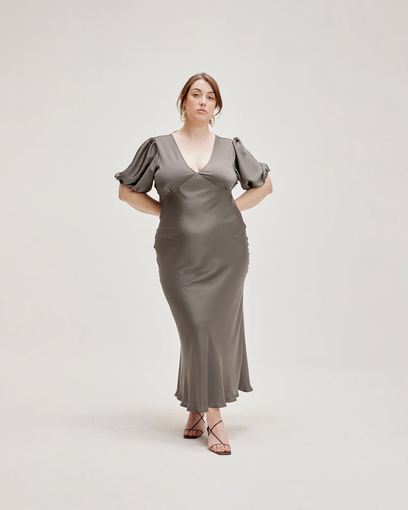 UMA SATIN DRESS CHARCOAL | Bias cut satin maxi dress with tie closure and a V-neck front and back. Back in a new luxe charcoal satin with elasticated puff sleeves and ruched detailing under the...