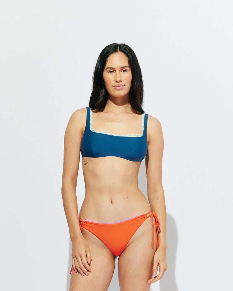 WYLIE TIE-SIDE BIKINI BOTTOM VERMILLION | Named after the Wylie's Baths in Sydney, these vermillion bikini bottoms are designed with a cheeky cut and adjustable side ties. Featuring a bright pink contrast lace trim, make it a matching set with the Wylie Triangle Bikini Top or...